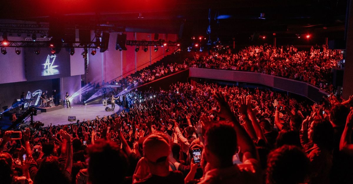 Vibrant live concert scene with an excited crowd under dramatic stage lighting.