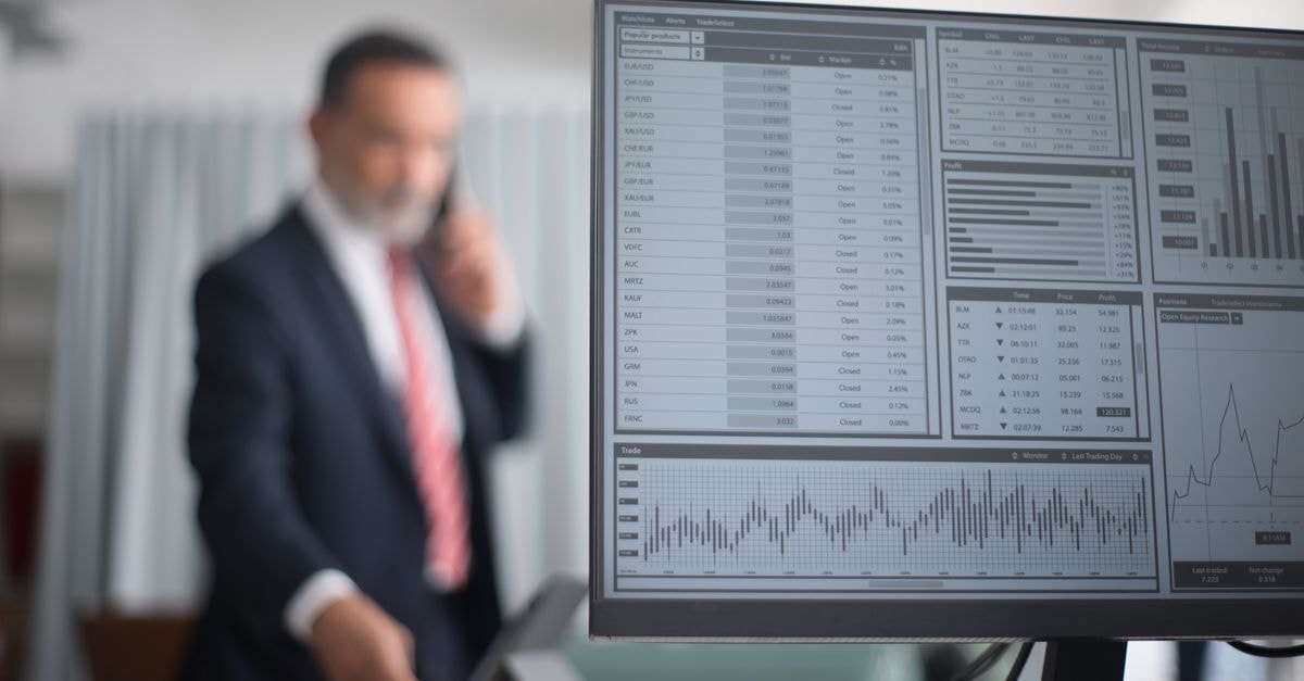 US administration pressures Apple over Chinese memory-chip sourcing Professional analyzing financial and stock market data on a computer screen in an office setting.