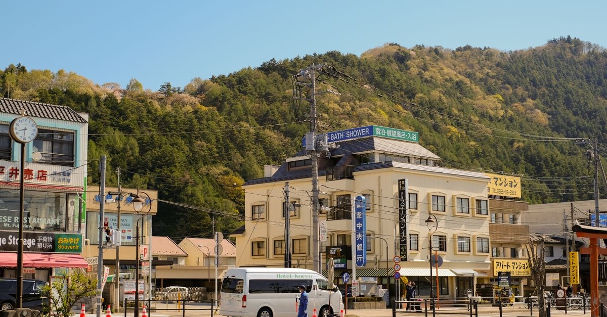 A vibrant town square surrounded by buildings and hills under a clear blue sky.