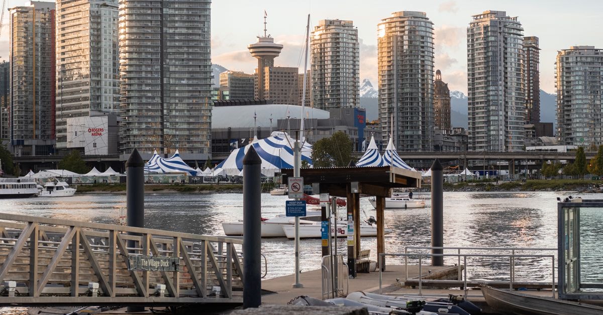 Scenic view of Vancouver's skyline reflecting on water during golden hour, captured from Village Dock.