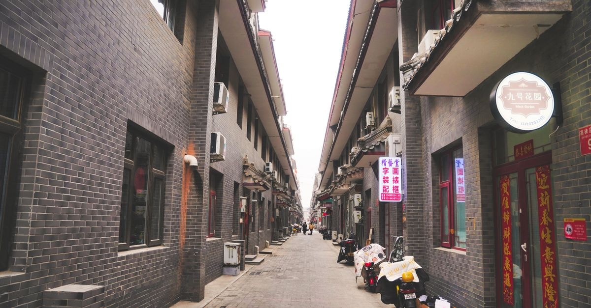 Langfang Travel Guide: A Quiet Pocket Between Beijing and Hebei Explore a traditional alleyway in Beijing, showcasing gray brick architecture and local signage.