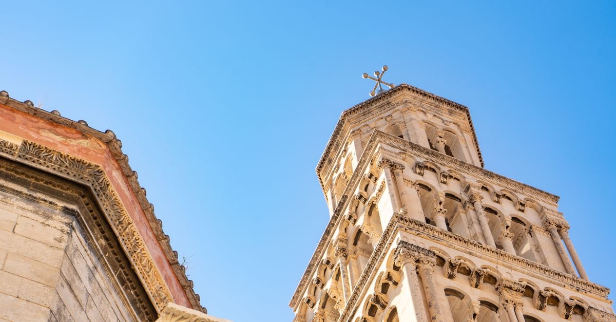 Hotel Cornaro in Split: A Heritage Hotel Steps from the Adriatic Detailed view of a historic tower in Split, Croatia against a clear blue sky.