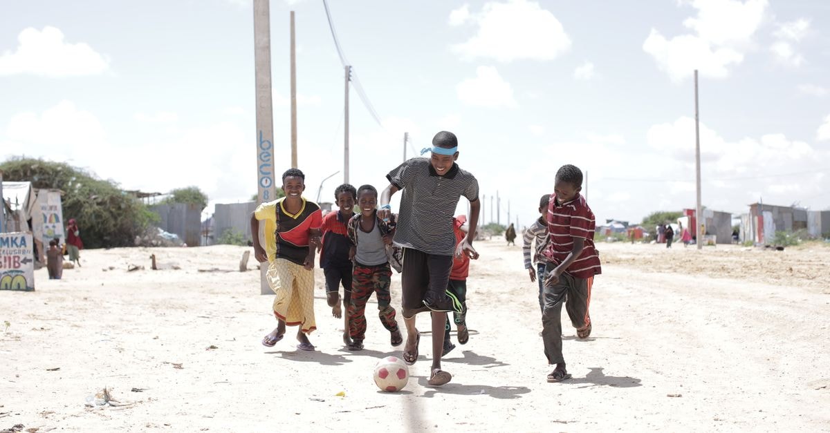 Happy children playing soccer on a sunny day in Somalia.