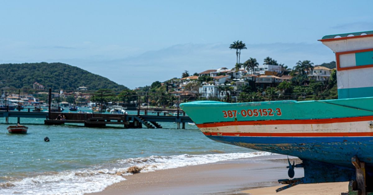 Colorful boat on the beach of Armação dos Búzios, Brazil, with scenic ocean view.