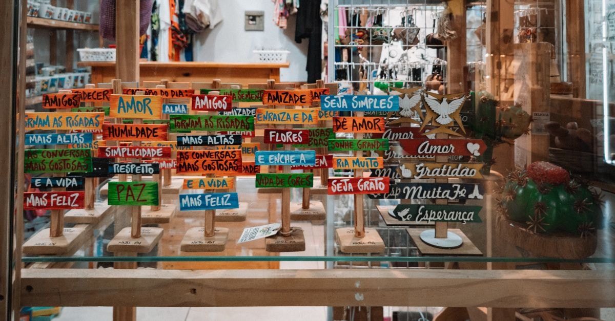 Vibrant wooden signs with uplifting messages on display in a cozy boutique setting.