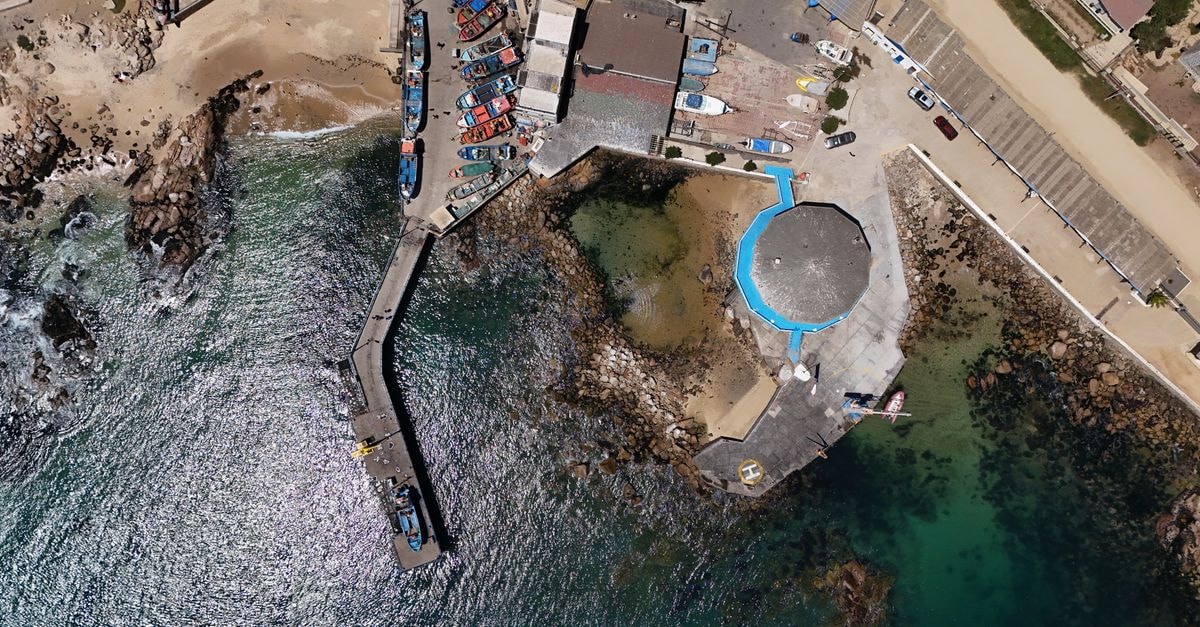 Concepción travel guide: getting around and tasting Chile An aerial perspective of a bustling dock with vibrant boats in El Quisco, Chile.