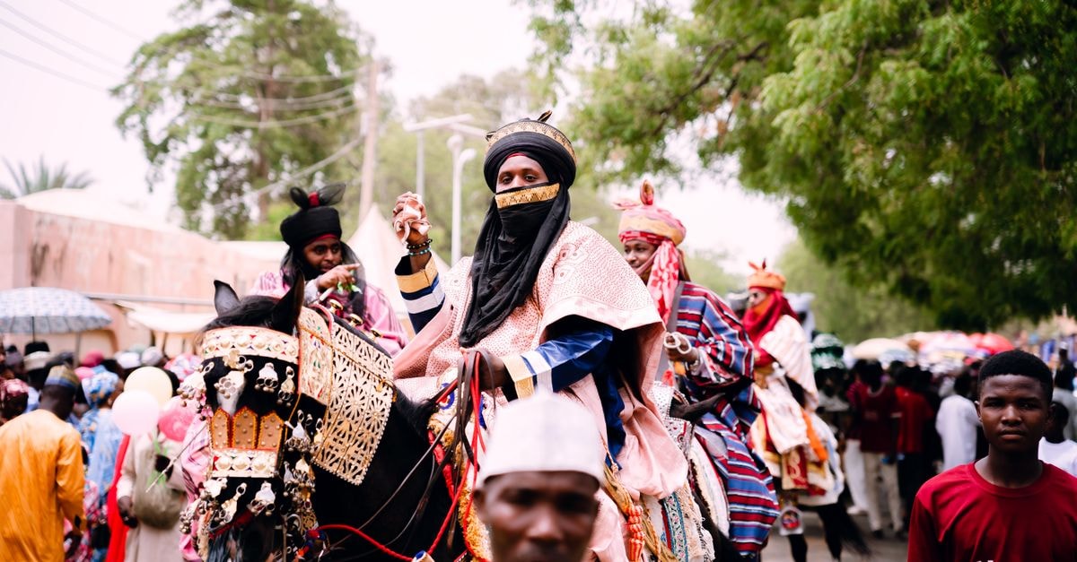Katsina Travel Guide: Planning Routes and Staying Connected Vibrant scene from a Durbar Festival parade featuring culturally dressed riders and decorated horses.