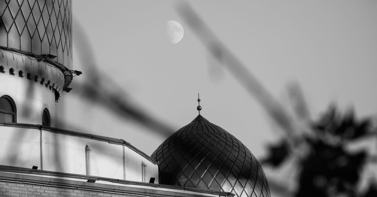 Monochrome image of a mosque dome under the moon in Aktau, Kazakhstan.