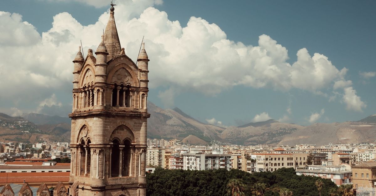 Villa Igiea in Palermo: A Belle Époque Palazzo by the Gulf Medieval bell tower with cityscape of Palermo, Sicily under a bright blue sky.