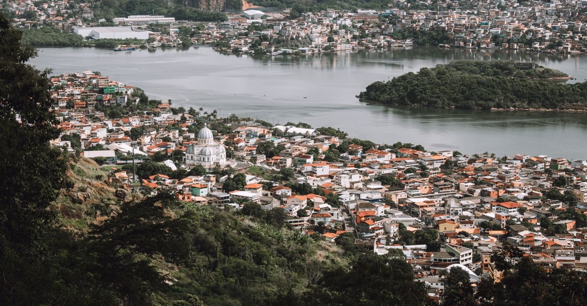 HTSS - Hotel de Trânsito de Subtenentes e Sargentos in Manaus: A Military Transit Stay in Compensa A breathtaking aerial shot of a city with a prominent dome building by a river, surrounded by lush greenery.