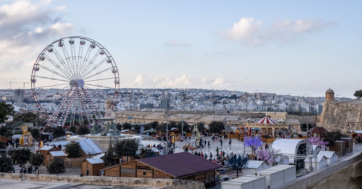 Valletta Travel Guide for July 2026: How to Plan Around the Heat, Crowds and Festa Season A scenic view of a Ferris wheel and carousel with a cityscape backdrop, capturing vibrant urban life.