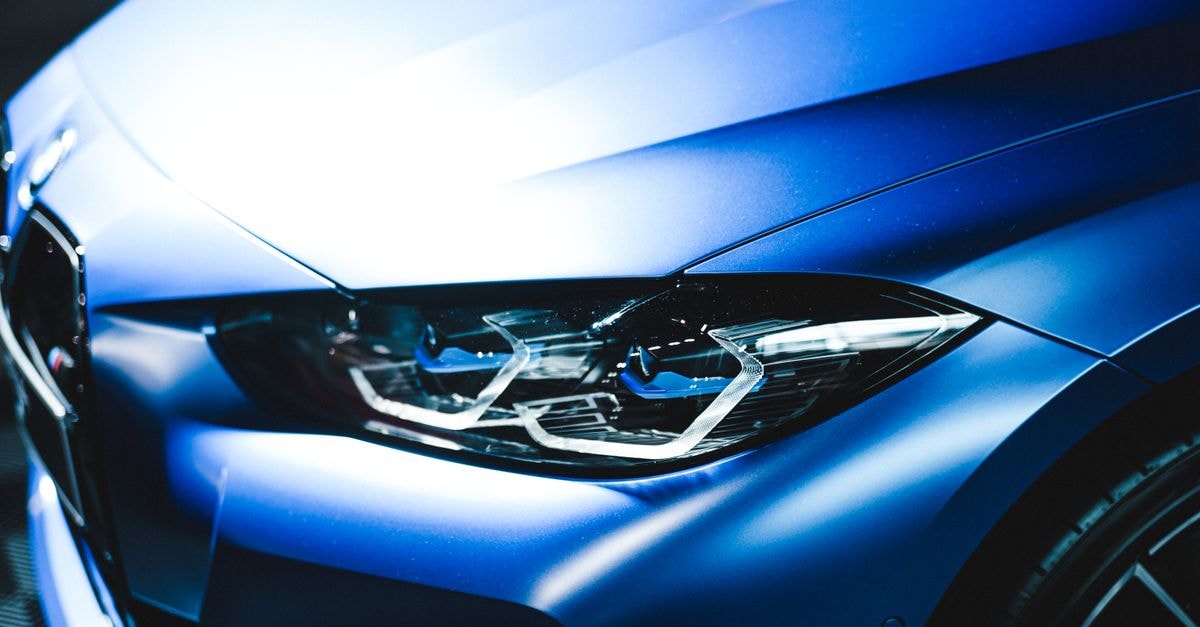 Tesla Issues Largest-Ever China Recall of Nearly 3 Million Vehicles Over Door-Handle Safety Detailed view of a sleek blue car focus on the headlight, emphasizing modern design.