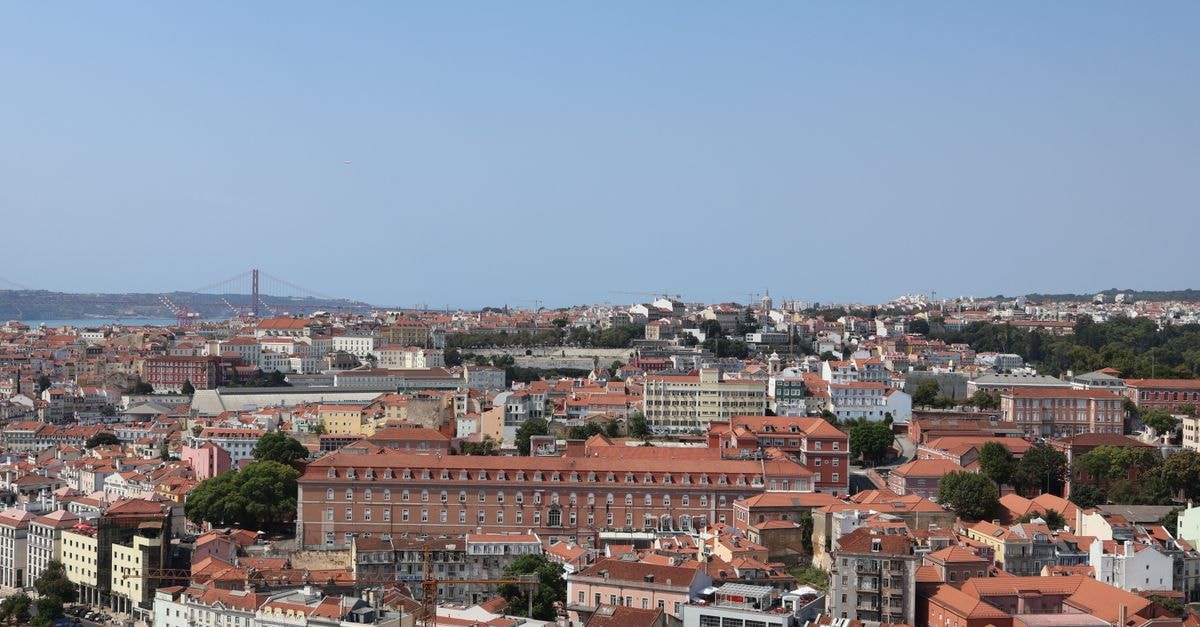 Aerial view of Lisbon showcasing its unique architecture and the Tagus Bridge on a sunny day.