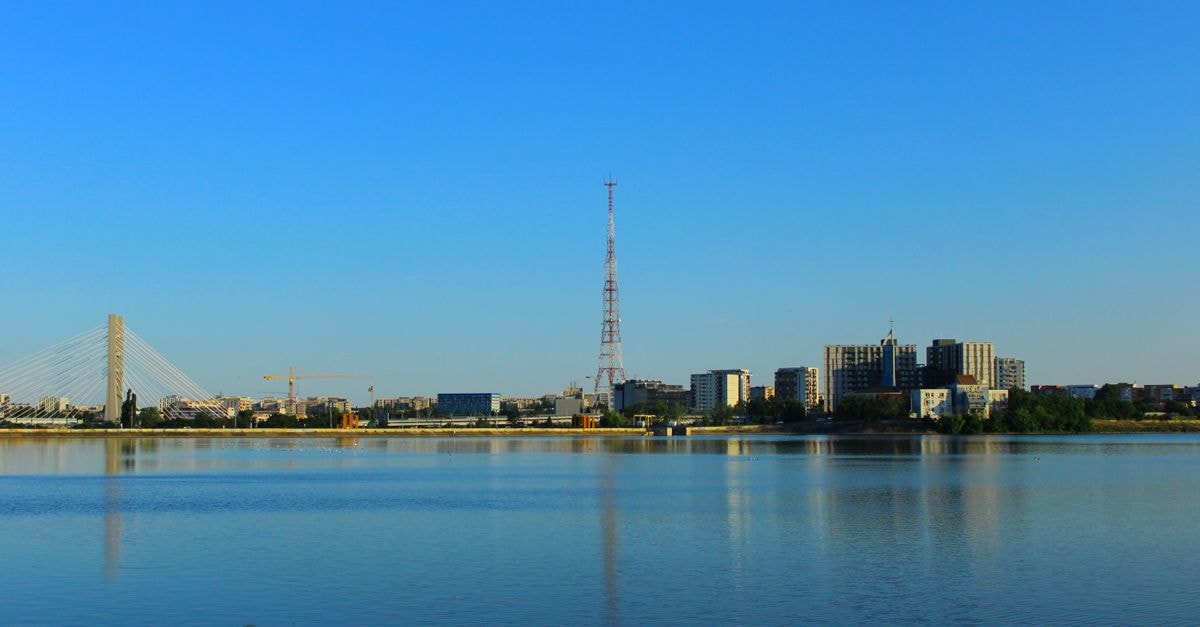 Grand Hotel Continental, Bucharest: A Belle Époque Address on Calea Victoriei Scenic view of Bucharest skyline with lake and bridge on a sunny day.