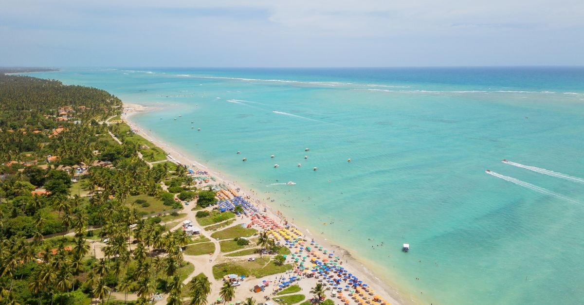 Maceió travel guide: an easygoing taste of Alagoas Stunning aerial view of Antunes Beach, Brazil with turquoise waters and vibrant umbrellas.