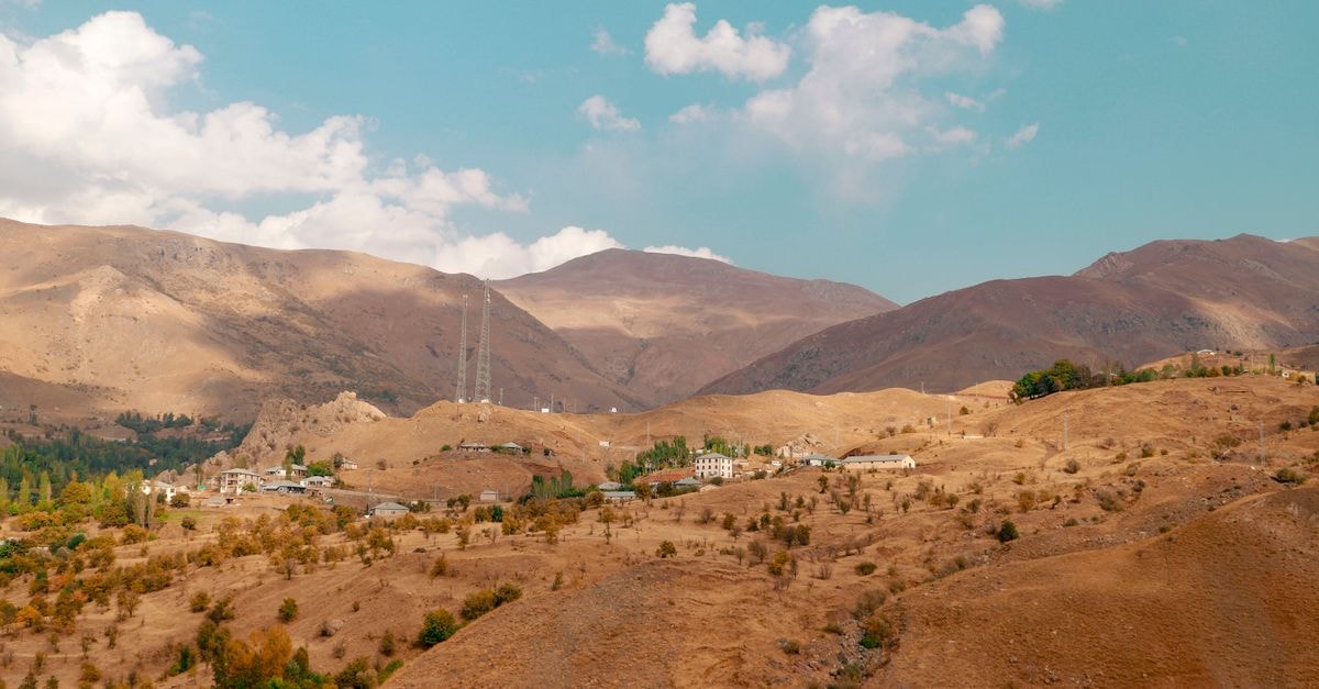 Beautiful arid landscape of Hakkâri, Türkiye, showcasing mountains and a small town.