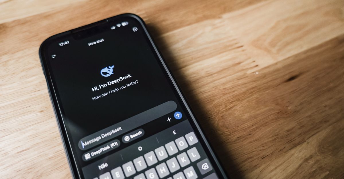 DeepSeek Cuts V4 Pro Pricing in China AI Race, Pauses New Funding Round Close-up of a smartphone showing a chat app interface on a wooden table.