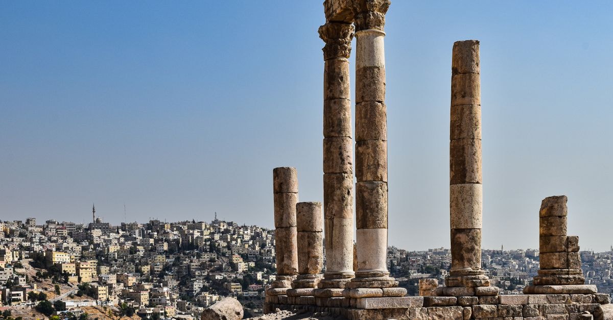 Zarqa travel guide: an authentic stop beyond Amman Ancient Roman temple columns in Amman with cityscape in the background under clear skies.
