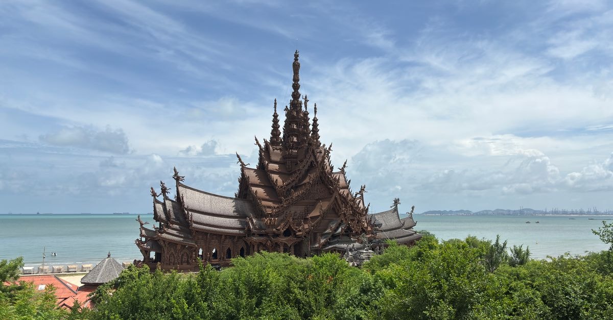 The BayView Pattaya: Beach Road Tower with Sweeping Bay Views Breathtaking view of Thailand's Sanctuary of Truth amidst lush greenery and a vibrant blue sea.