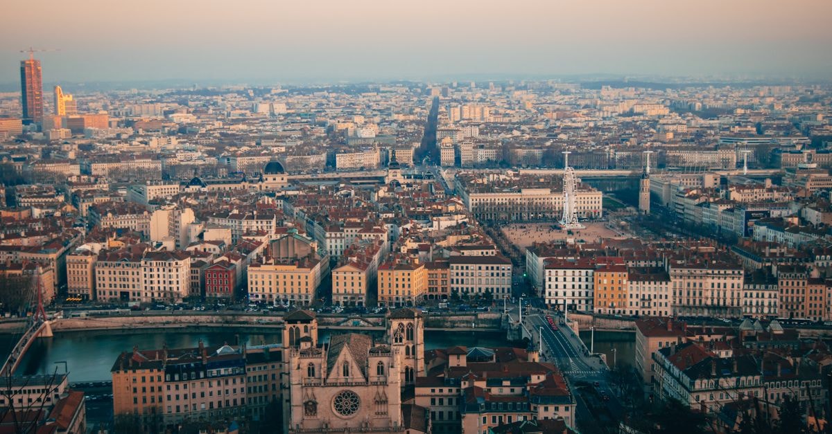Stunning aerial view of Lyon cityscape during sunset, showcasing historic architecture and vibrant city life.