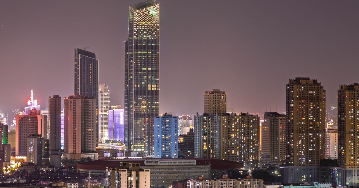 Shenzhen travel guide: a subtropical city of tech, coast and night markets A bustling city skyline at night showcasing illuminated skyscrapers against a clear sky, illustrating urban vibrancy.