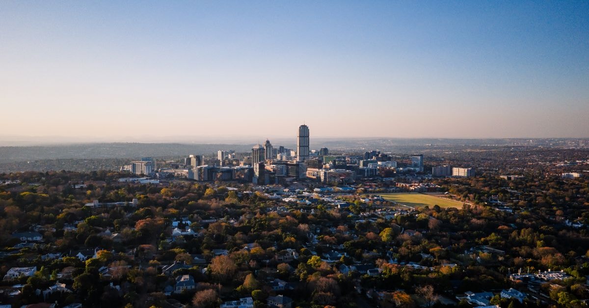 ANEW Hotel Parktonian in Johannesburg: Braamfontein Base Near the CBD Stunning aerial view of Sandton, Gauteng, showcasing urban skyline and suburban layout under a clear sky.
