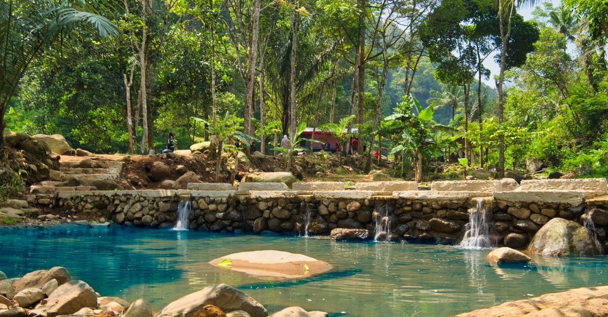 Dimbokro Travel Guide: A Quiet Stop in the Lacs District Serene natural pool in a lush green forest with small waterfalls. Perfect for nature lovers.