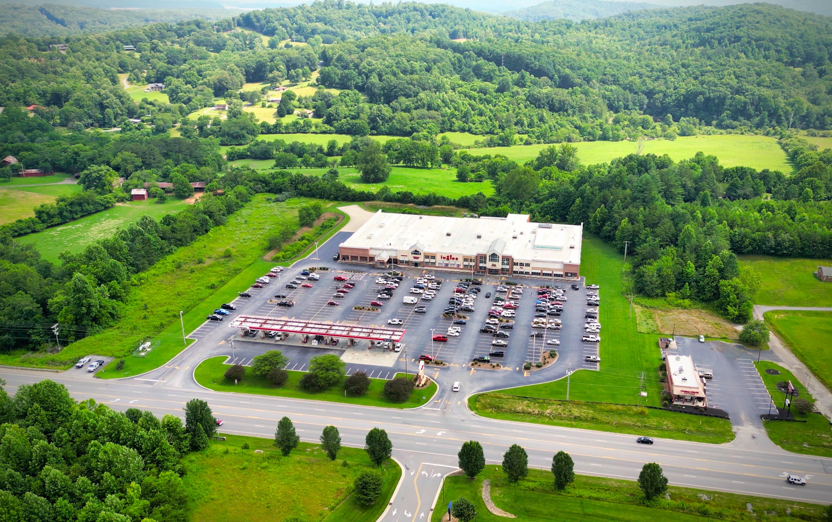Ingles Markets: Steady Grocer, Tight Capital Discipline, But Limited Growth Runway at a Premium Multiple Illustration for Ingles Markets: Steady Grocer, Tight Capital Discipline, But Limited Growth Runway at a Premium Multiple: An aerial of an Ingles grocery store and gas station in Hayesville, North Carolina.jpg