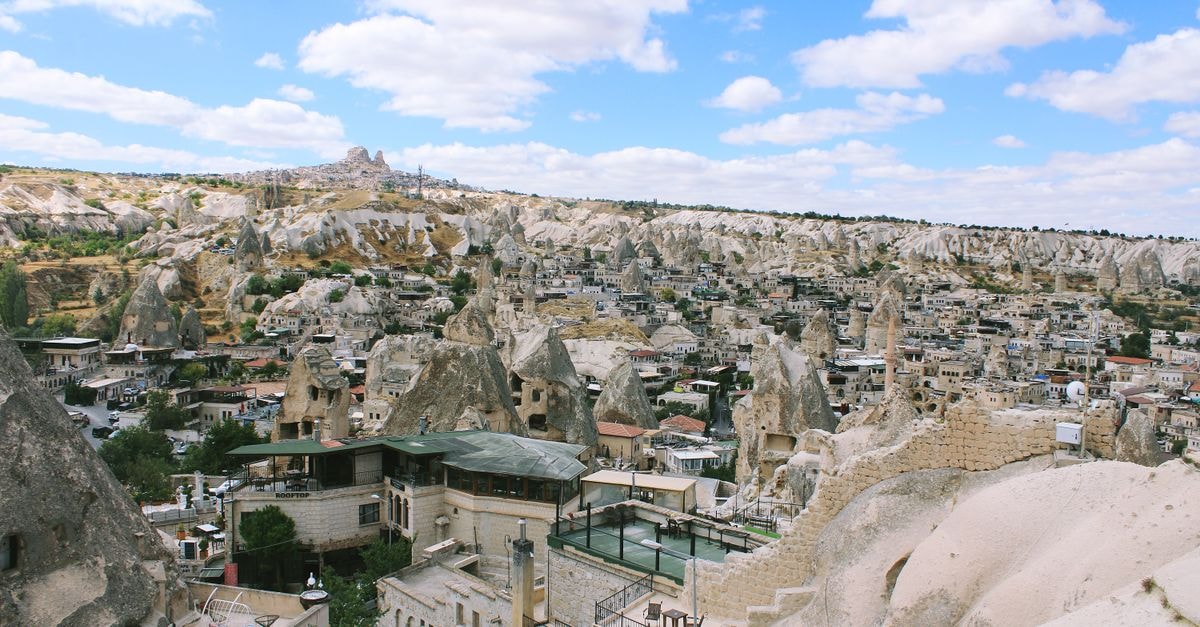 Explore the unique fairy chimneys in Göreme, Cappadocia, showcasing stunning rock formations under a blue sky.