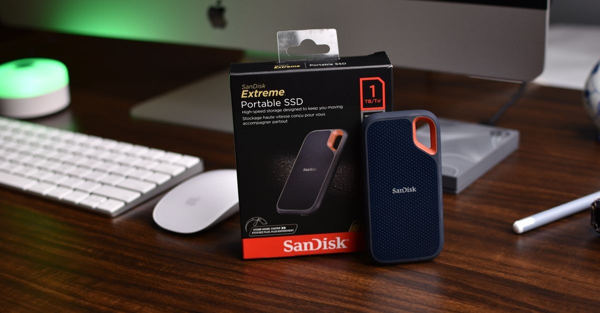 SanDisk Extreme Portable SSD 擺在配有 iMac 的現代辦公桌上。