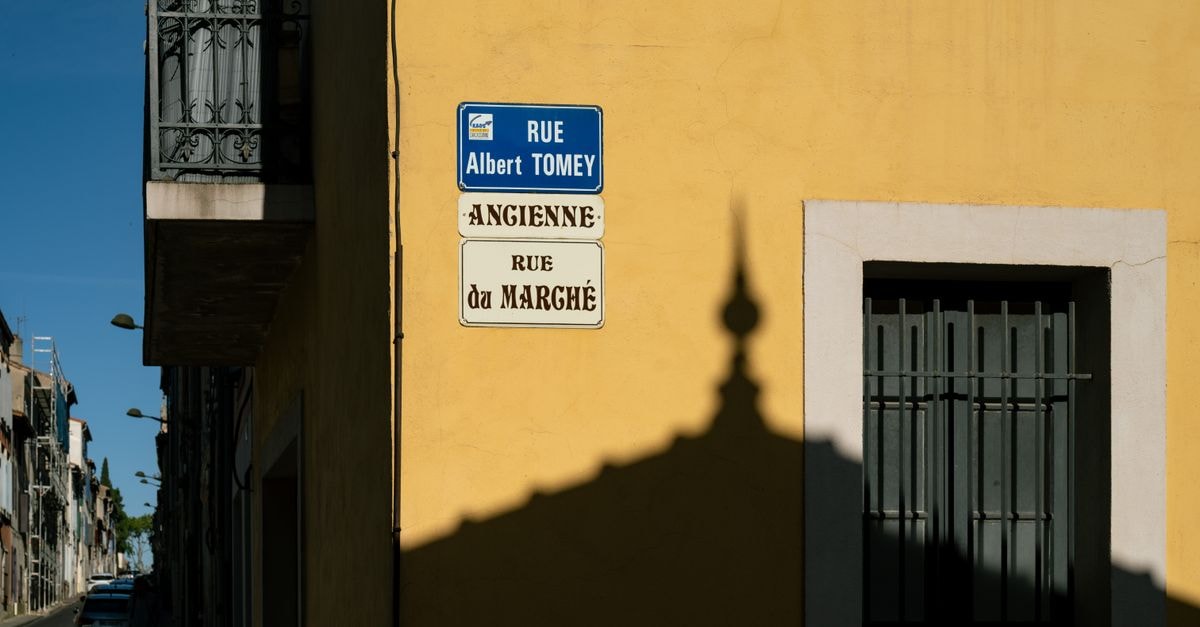 Jalsa Beach Hotel & Spa in Riviere du Rempart: A Turquoise Lagoon Retreat Street signs on Rue Albert Tomey with dramatic shadows in Carcassonne, France.