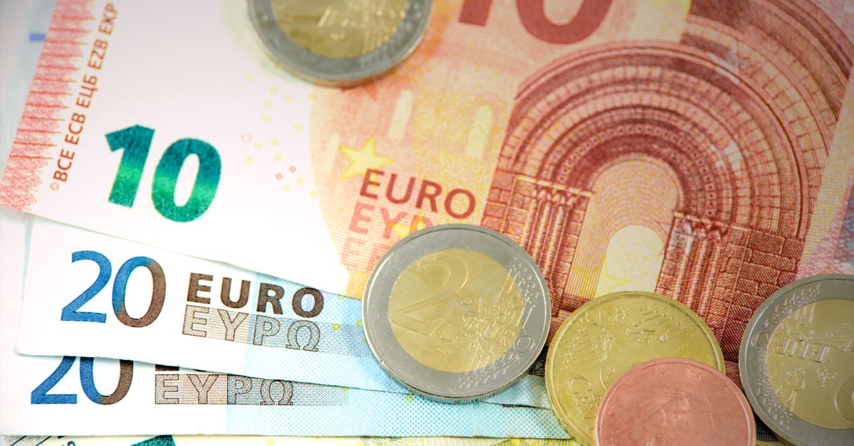 Detailed shot of Euro banknotes and coins showcasing currency denominations.