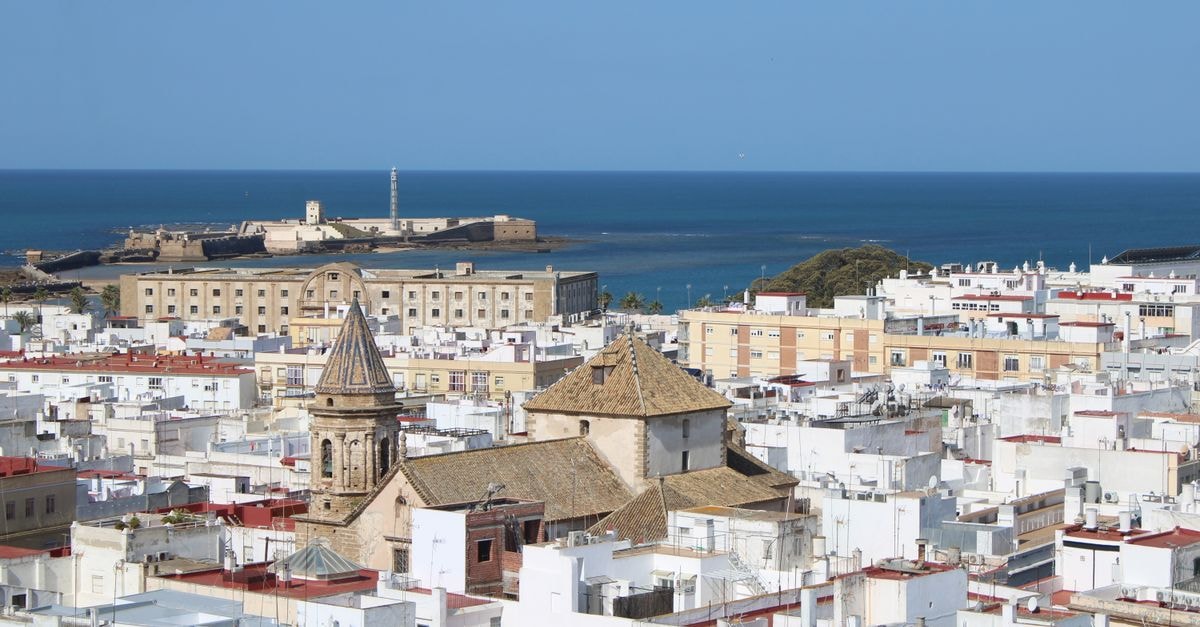 Hotel Valle de Santiago, San Cristóbal: Garden Boutique Near Centro Clínico San Cristóbal Stunning aerial view of Cádiz cityscape with vibrant roofs and Castillo de San Sebastian by the ocean.
