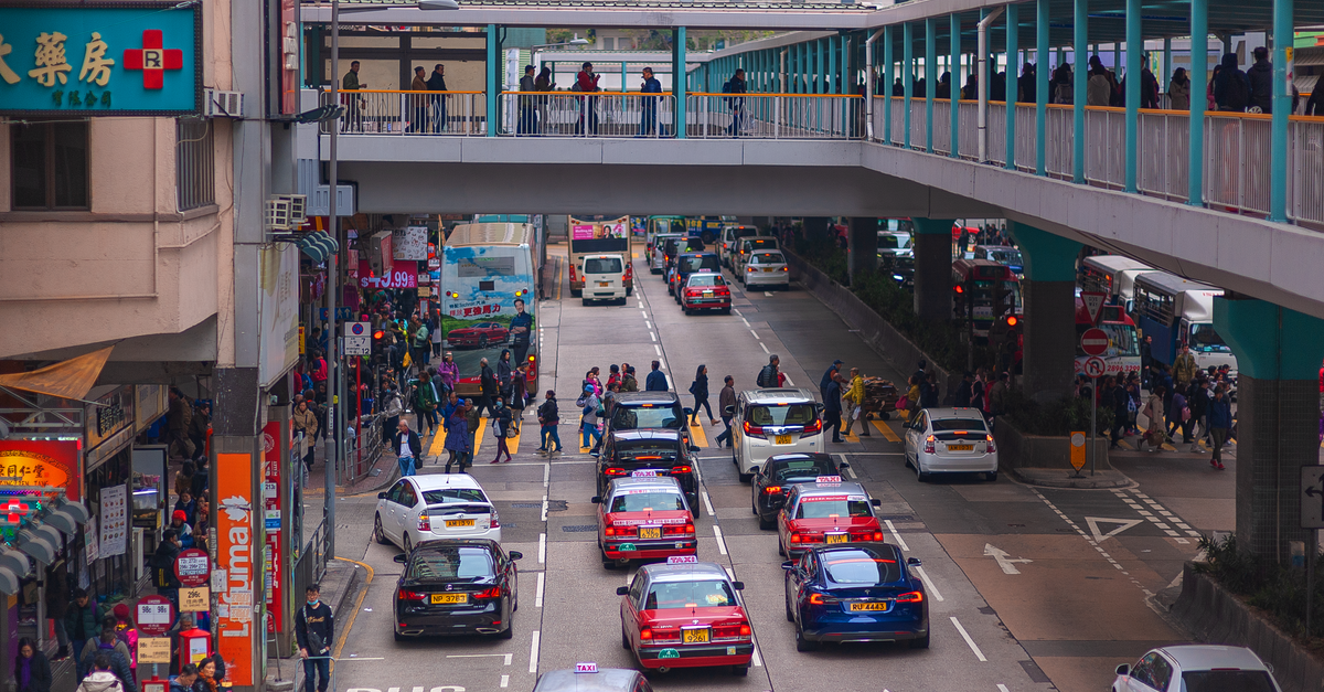 A Slow-Paced Hong Kong Travel Guide for Curious Visitors Vibrant city life in Hong Kong with taxis and pedestrians on a bustling street.