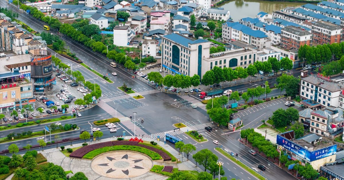 Kessai Hotel in Jining: Gateway by Kessai Bridge in the High-Tech Zone Aerial view of a modern cityscape in China with roads, buildings, and greenery.
