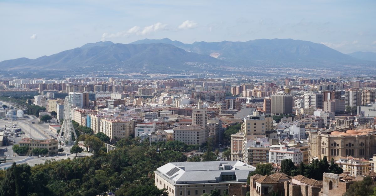 Hampton by Hilton Malaga Martiricos in Málaga: A Practical Stay on Paseo Martiricos Panoramic view of Malaga cityscape with mountains, capturing architectural details and natural beauty.