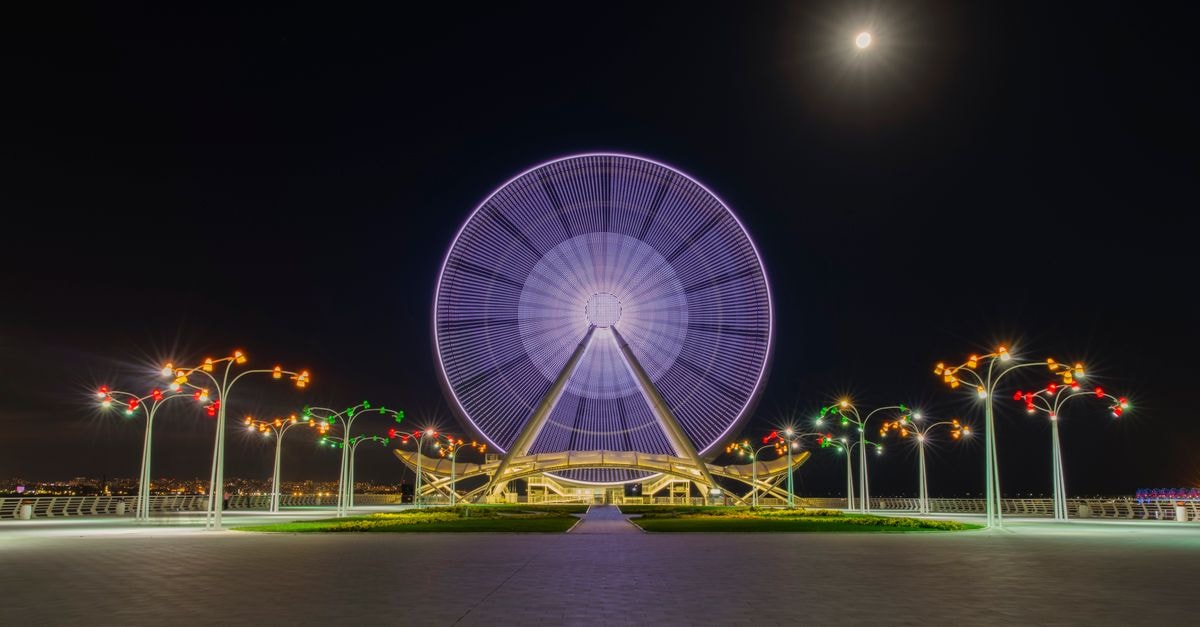 Teresina Travel Guide: Rivers, Parks and Slow Piauí Evenings Captivating night view of the illuminated Baku Ferris Wheel under a full moon.