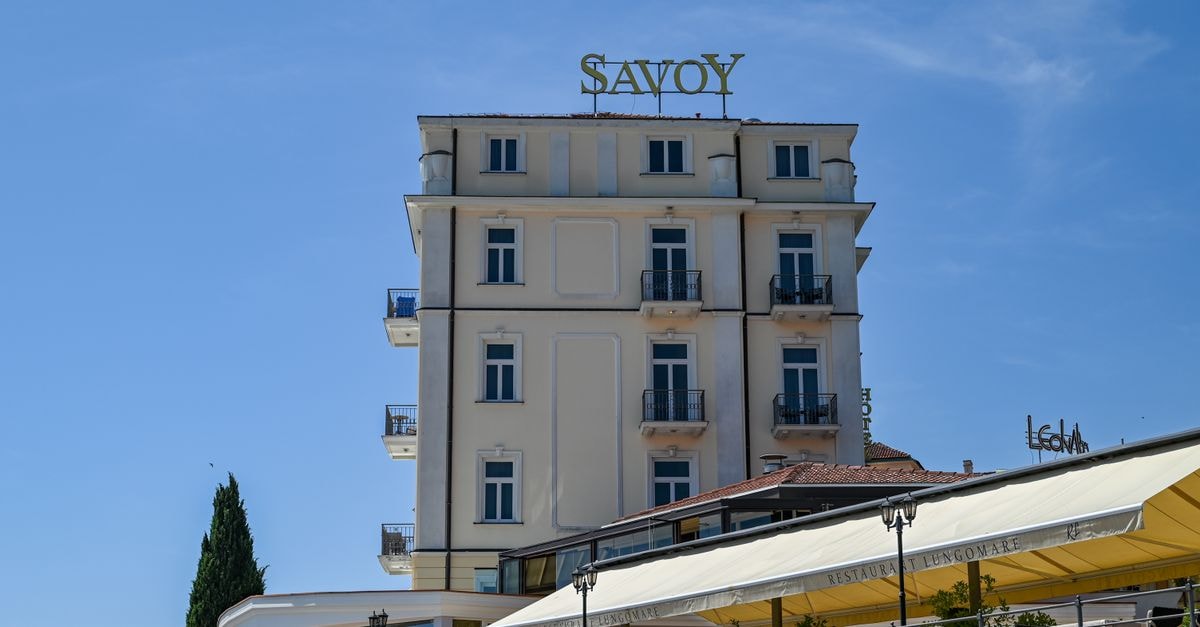 The Savoy Hotel in Limerick: A 1920s-Inspired City Centre Retreat A low angle view of the Savoy Hotel with clear blue skies in Opatija, Croatia, showcasing its elegant architecture.