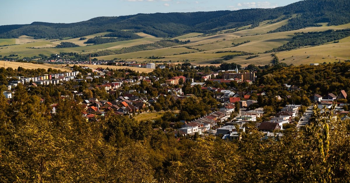 Art Pension in Banská Bystrica: A Quiet Stay by the City Park A picturesque view of Lipany, Slovakia with surrounding hills and vibrant autumn foliage, captured in daylight.