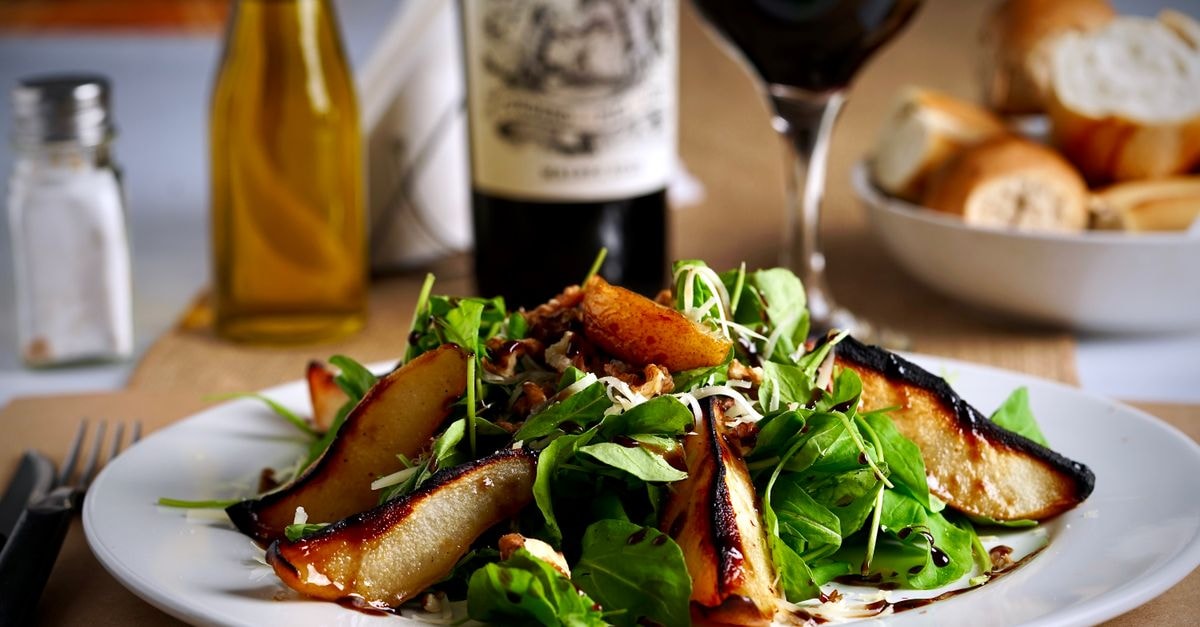 Rancagua Travel Guide: Culture, Food, and Practical Context A delectable pear salad paired with red wine and bread for an elegant dining experience.