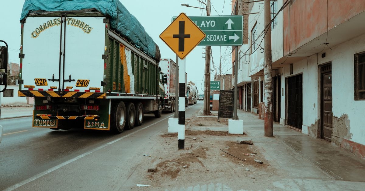 Tranquil street view with truck and signs in Trujillo, Peru, showcasing daily life in the city.