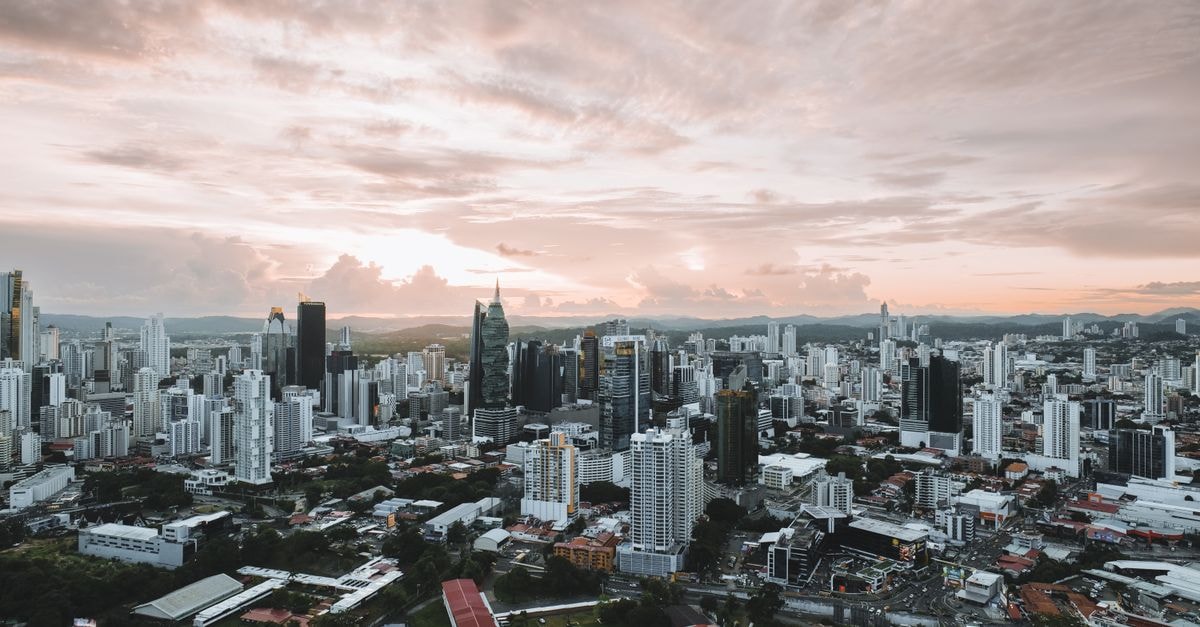 Dramatic aerial view of Panama City skyline during sunset showcasing modern skyscrapers.