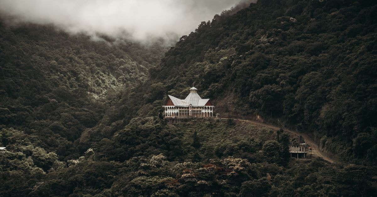 Moyobamba Travel Guide: Reaching Peru's Hidden Cloud Forest City A captivating view of a lone building nestled within a misty mountain forest.