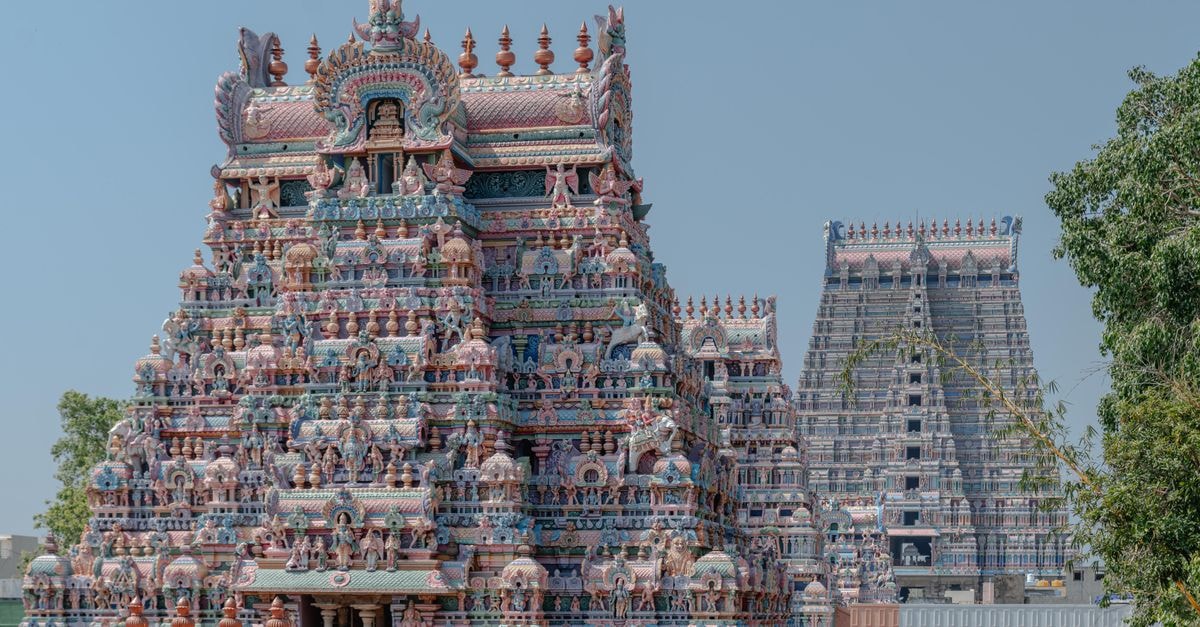 Madurai Travel Guide: Planning Tips, Costs and Things to Do View of the colorful and detailed gopuram of the Srirangam Temple in Tiruchirappalli, India, under a clear blue sky.