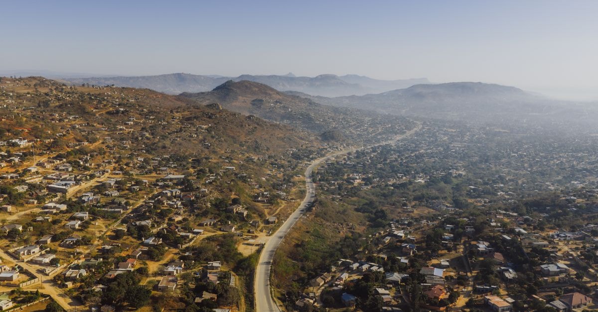 Aerial photograph capturing expansive rural landscape near eSwatini border, showcasing winding road through hills.