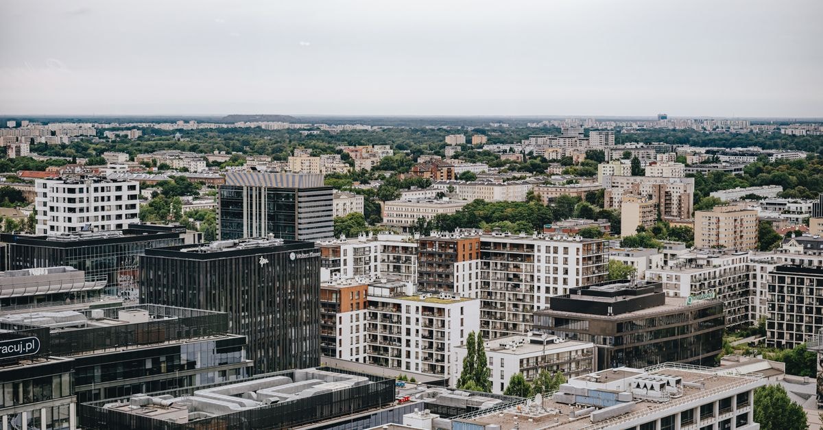 Aerial view of Warsaw skyline featuring modern and residential buildings under cloudy sky.
