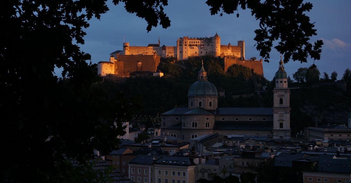 Majestic view of Hohensalzburg Fortress overlooking Salzburg at twilight.