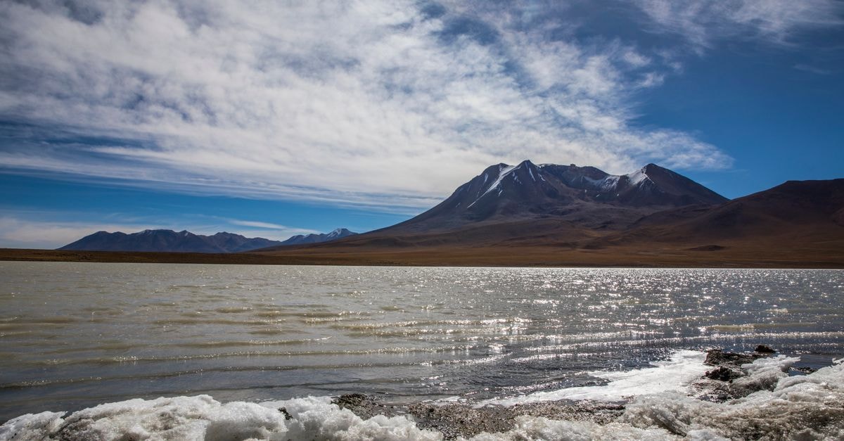 Latacunga travel guide: a calm Andean base beneath Cotopaxi Beautiful mountain lake with snowy foreground and serene reflections in Sucre, Bolivia.