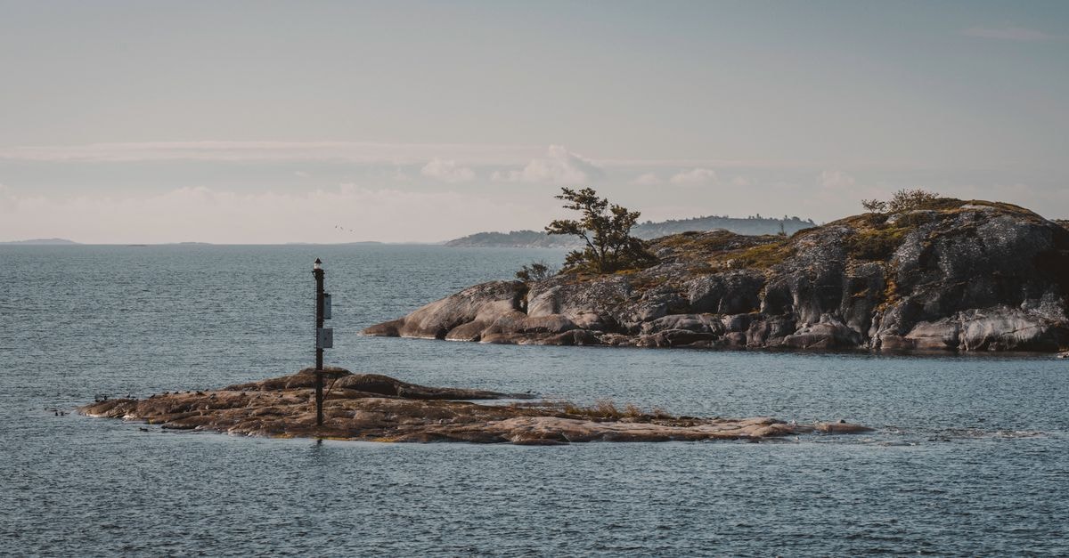 Peaceful seascape with a small rocky island and calm waters, perfect for travel inspiration.