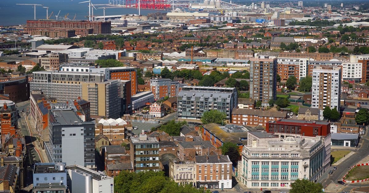 Stunning aerial view of Liverpool showcasing urban architecture and skyline under clear blue skies.